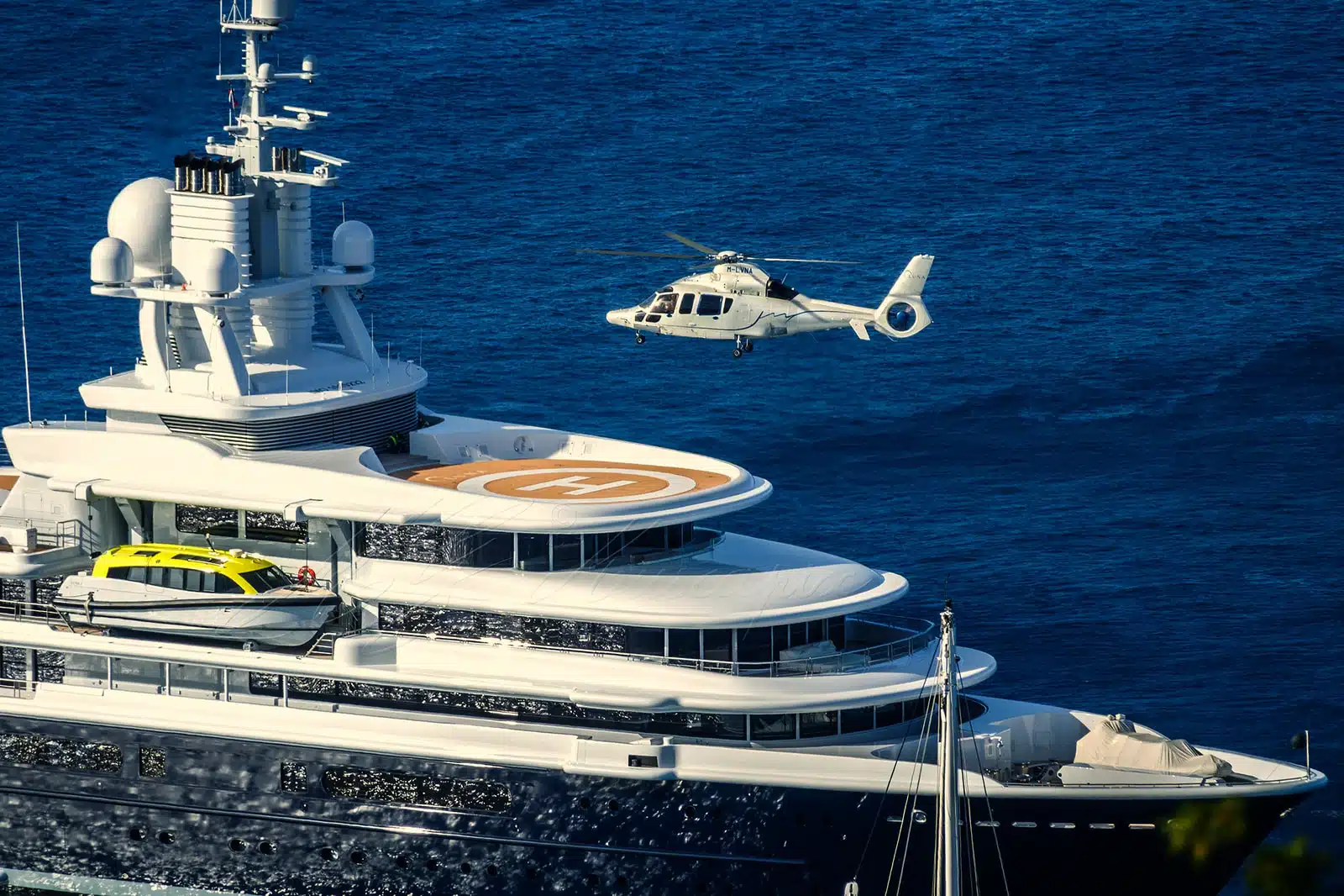 Helicopter above a superyacht cruising in the Mediterranean