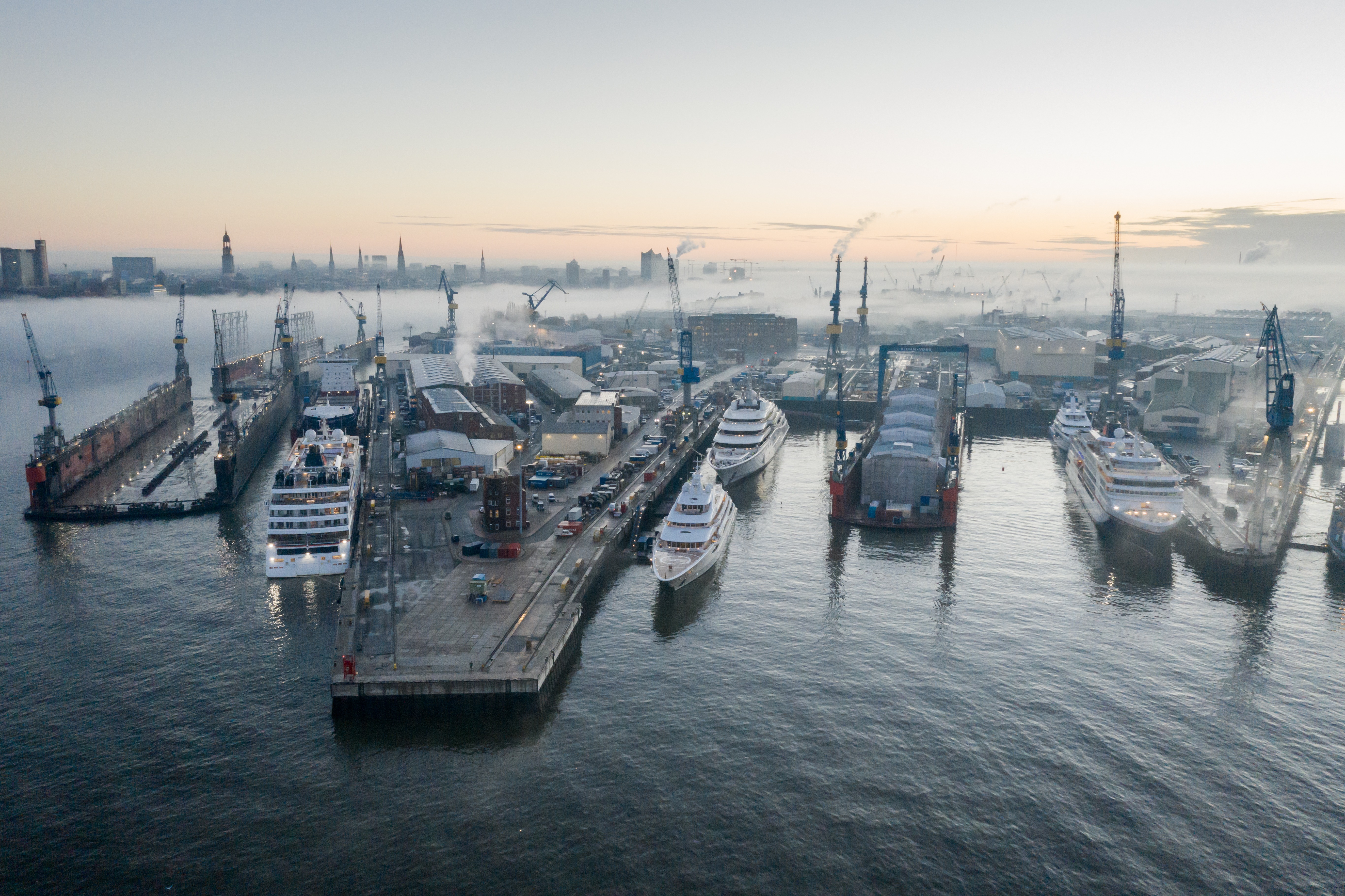 Superyacht hull under construction in a covered shipyard hall