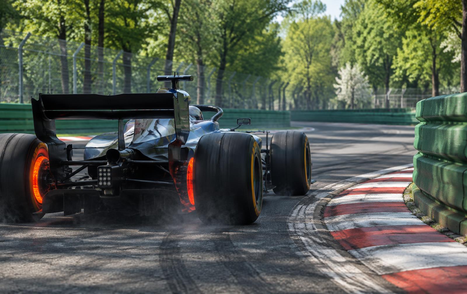 Single-seater braking hard into a tight hairpin behind barriers