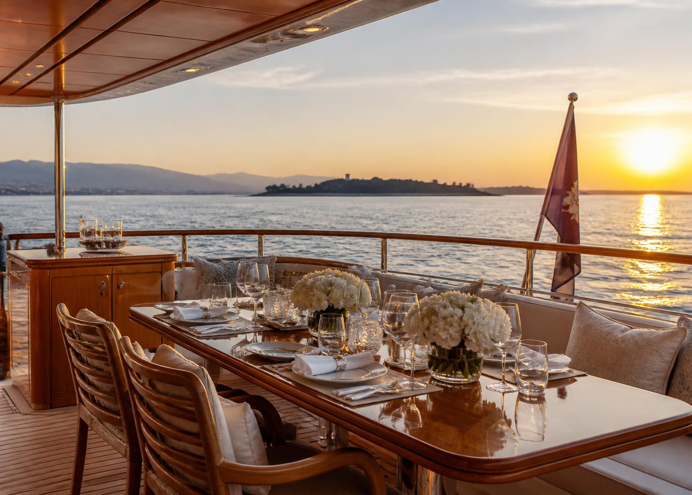 Dining table set on the aft deck of a yacht in the bay of Cannes at sunset