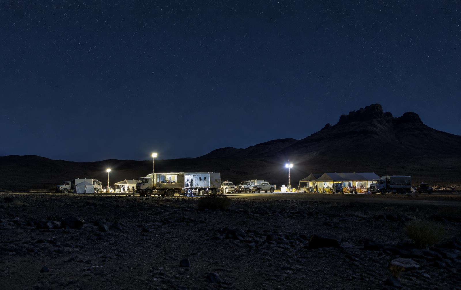 Motorsport service camp lit at night in the Saudi desert