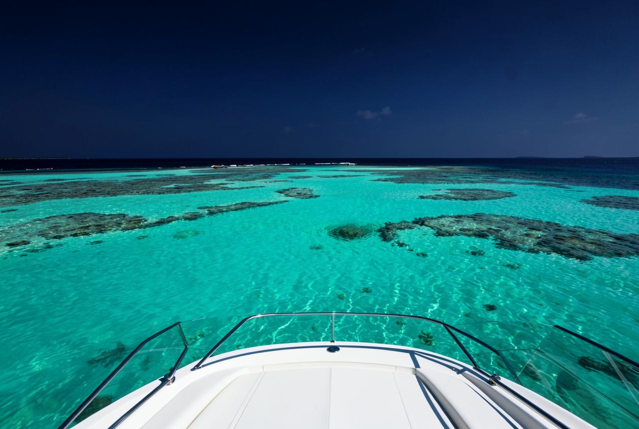 Motor yacht anchored over pale turquoise water in the Bahamas