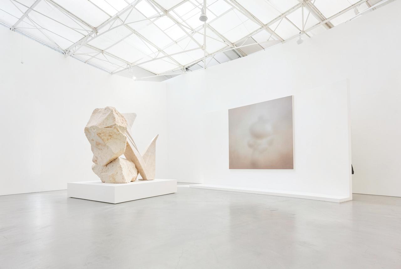 Sculpture and a large-format work in a bright white contemporary art fair pavilion