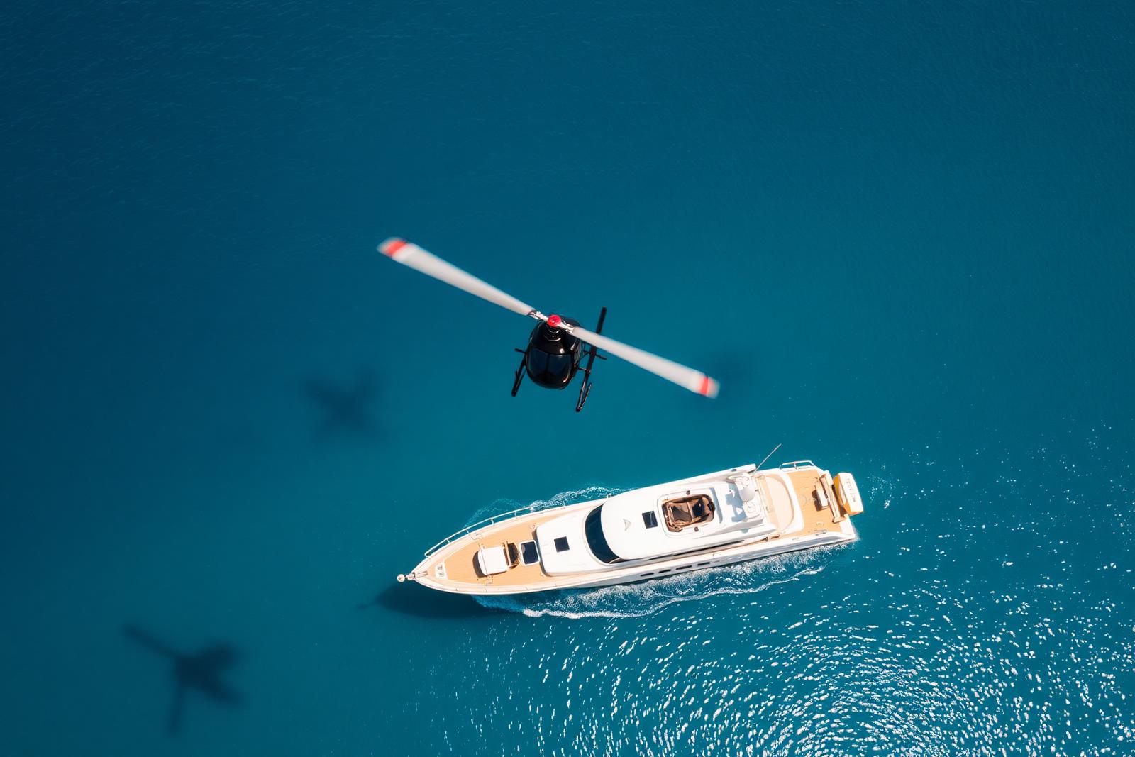 Helicopter above a superyacht cruising in the Mediterranean