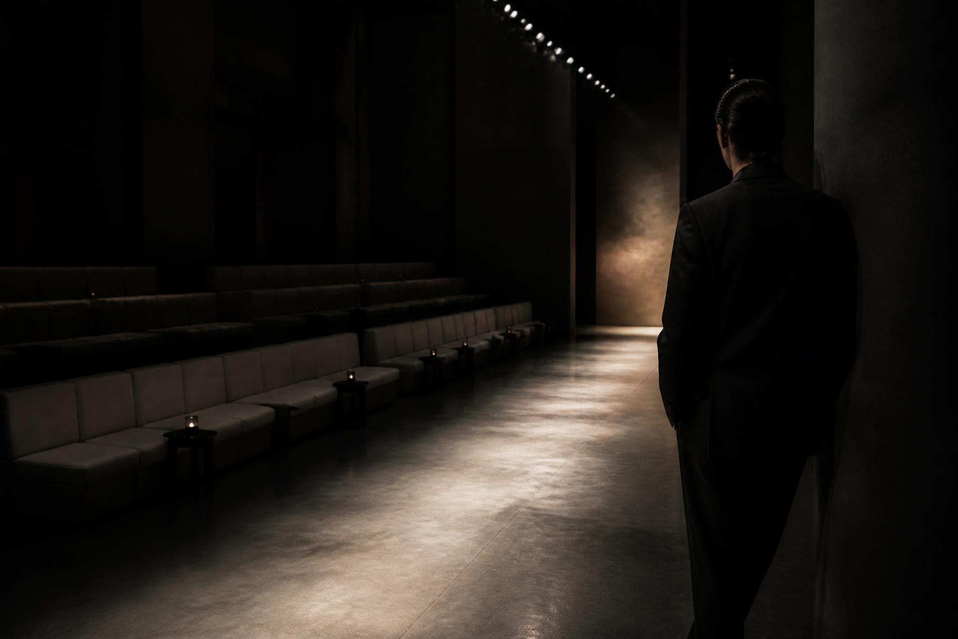Empty seating along a dark minimalist runway before a fashion presentation