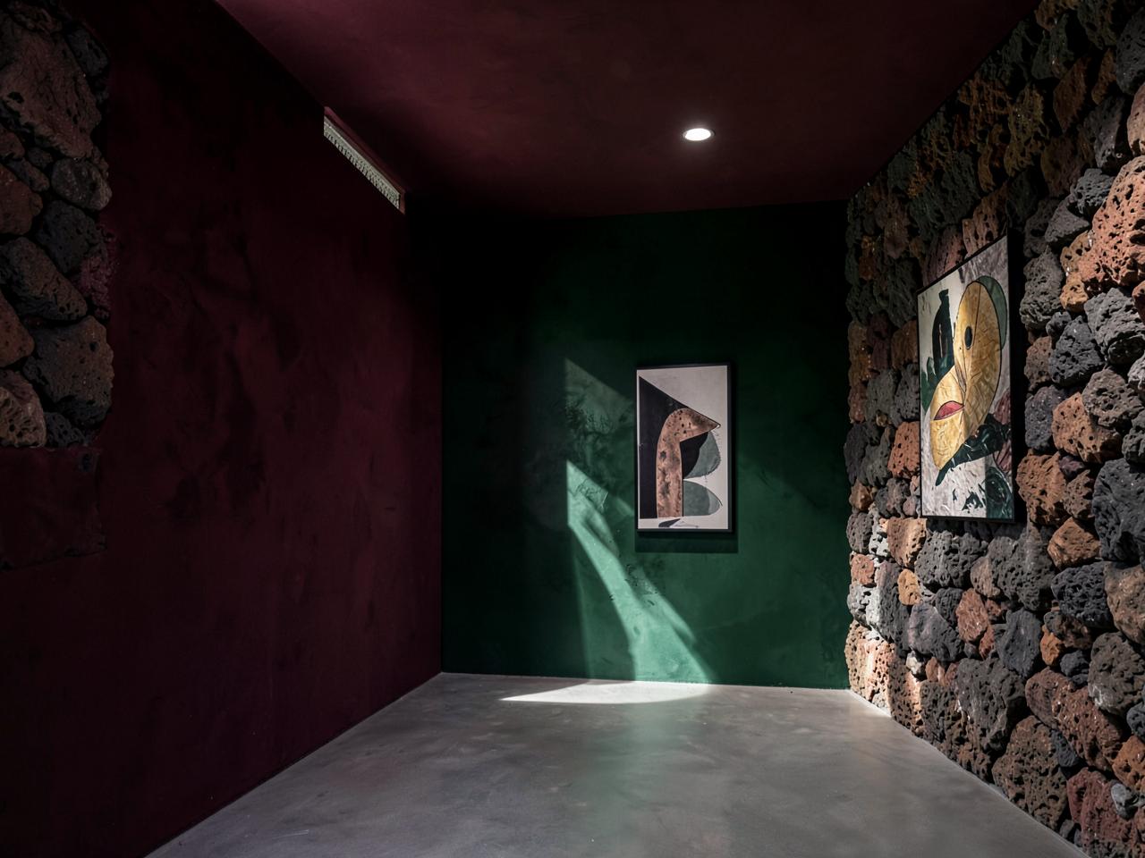 Mexican modernist interior with volcanic stone, coloured plaster walls and contemporary artworks