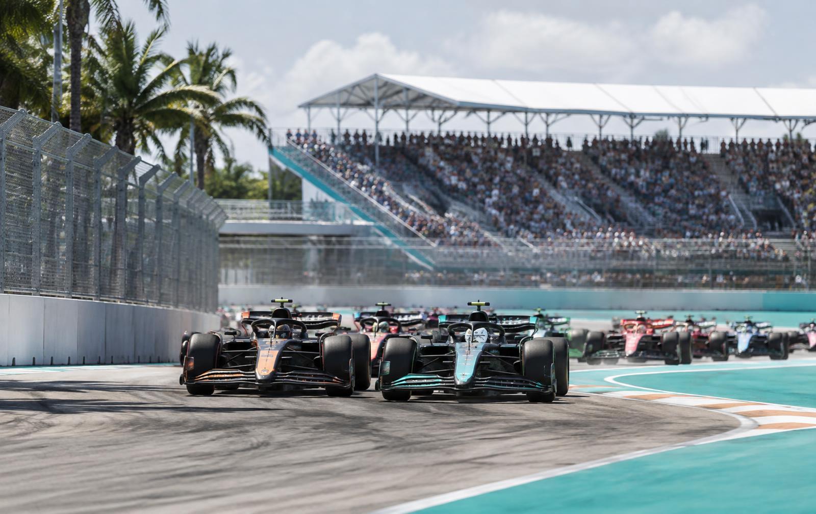 Race cars braking at a sunlit Miami temporary circuit