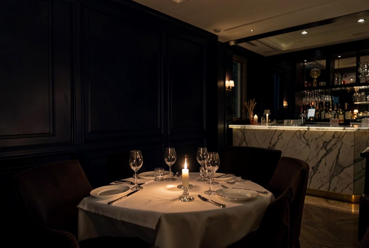 Candlelit private dining room with navy panelling and a marble bar in a Cannes hotel at night