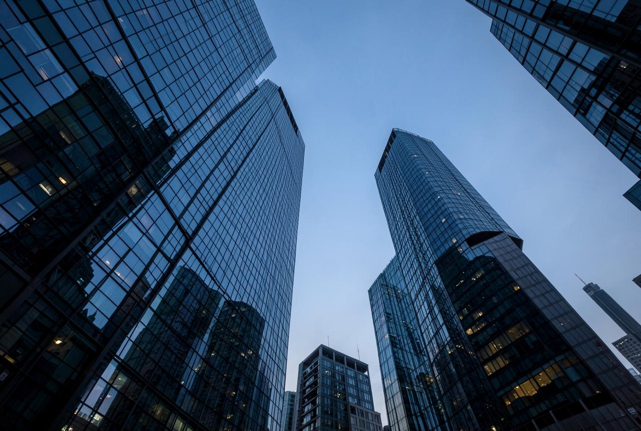 Glass towers of a business district at dusk seen from below